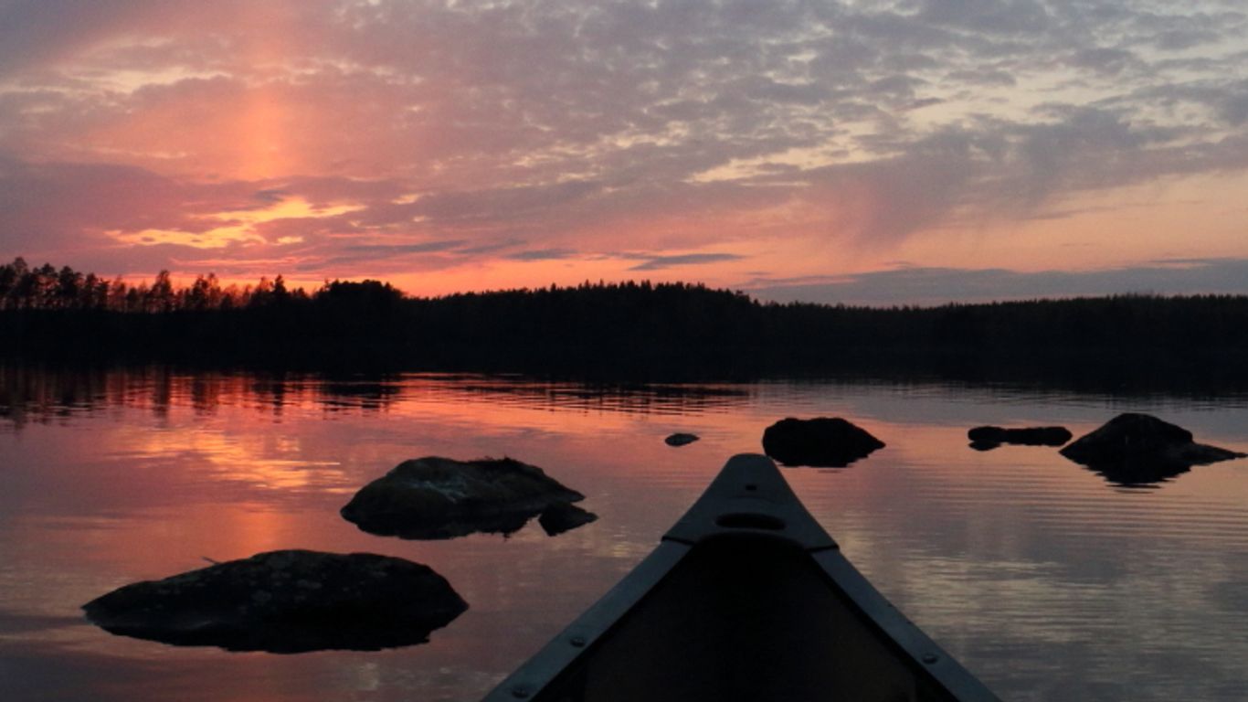 Auringonlasku ja kanootin keula.