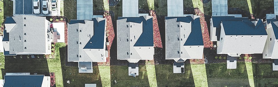 Drohnenaufnahme von weißen Wohnimmobilien mit grauen Dächern