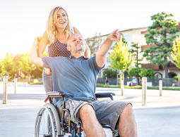 S invalidním vozíkem na palubě Žena tlačí může na invalidním vozíku