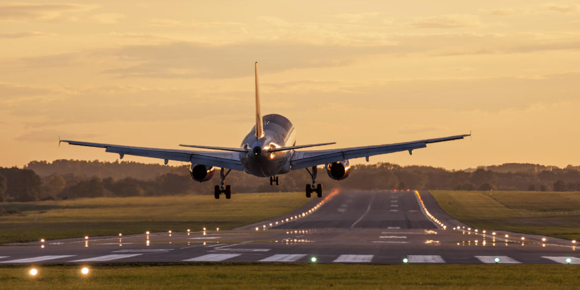 Travel with FlixBus to your next flight A plane landing with a golden sky