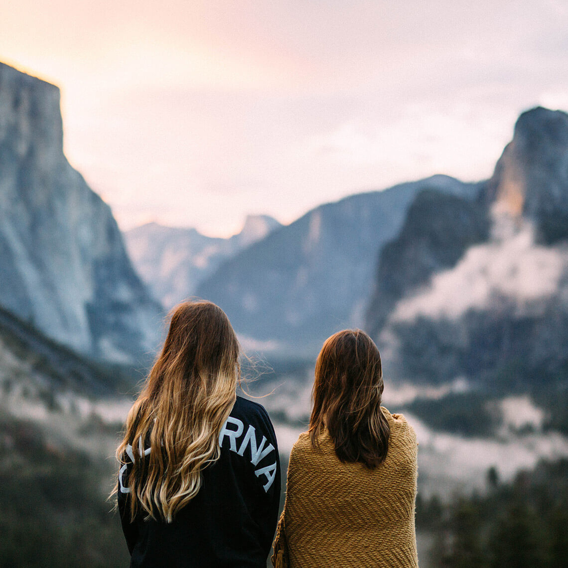 Viaja con FlixBus a tus próximas vacaciones. Dos mujeres disfrutando de la vista de las montañas.