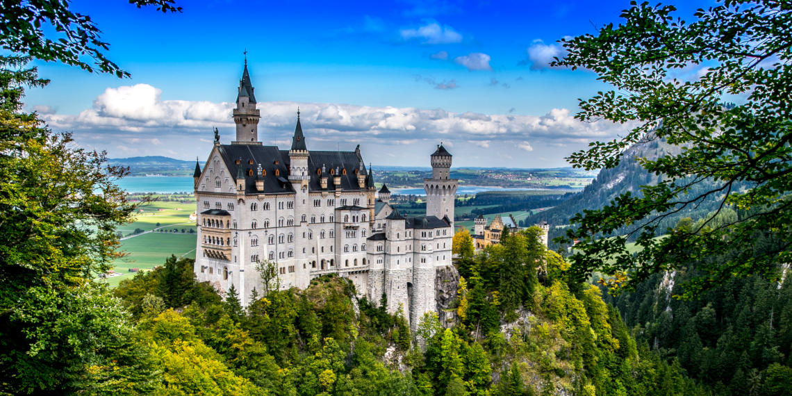 Reisen Sie mit FlixBus und erkunden Sie Schloss Neuschwanstein Erstaunliches Schloss Neuschwanstein mit herrlicher Aussicht, umgeben von Natur