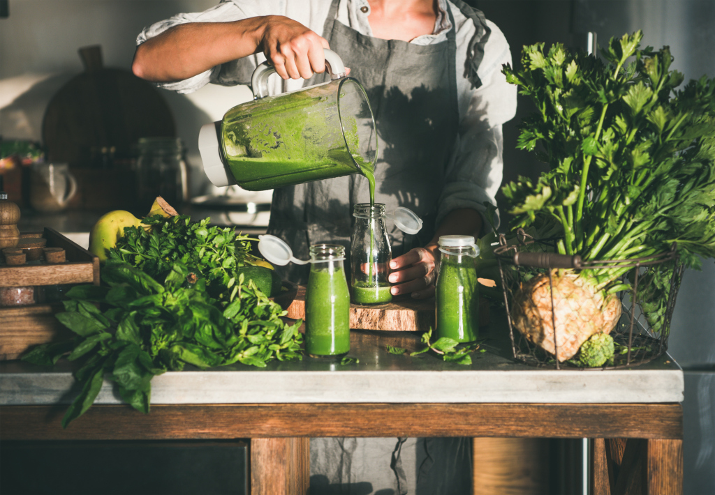 Frau beim Zubereiten grüner Smoothies Frau beim Zubereiten grüner Smoothies