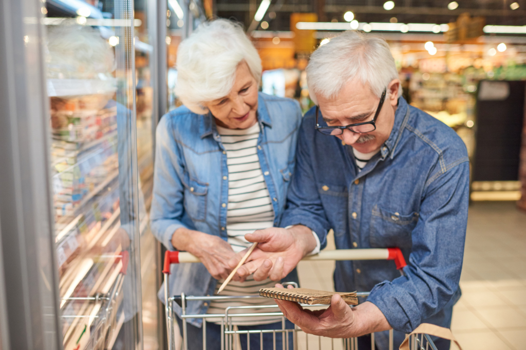 Paar im Supermarkt kontrolliert Einkaufszettel Paar im Supermarkt kontrolliert Einkaufszettel