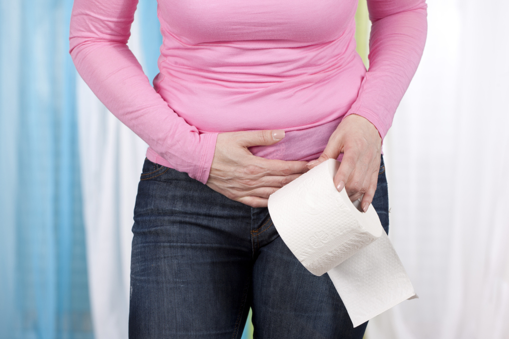 Frau mit Blasenentzündung und Toilettenpapier in der Hand Frau mit Blasenentzündung und Toilettenpapier in der Hand