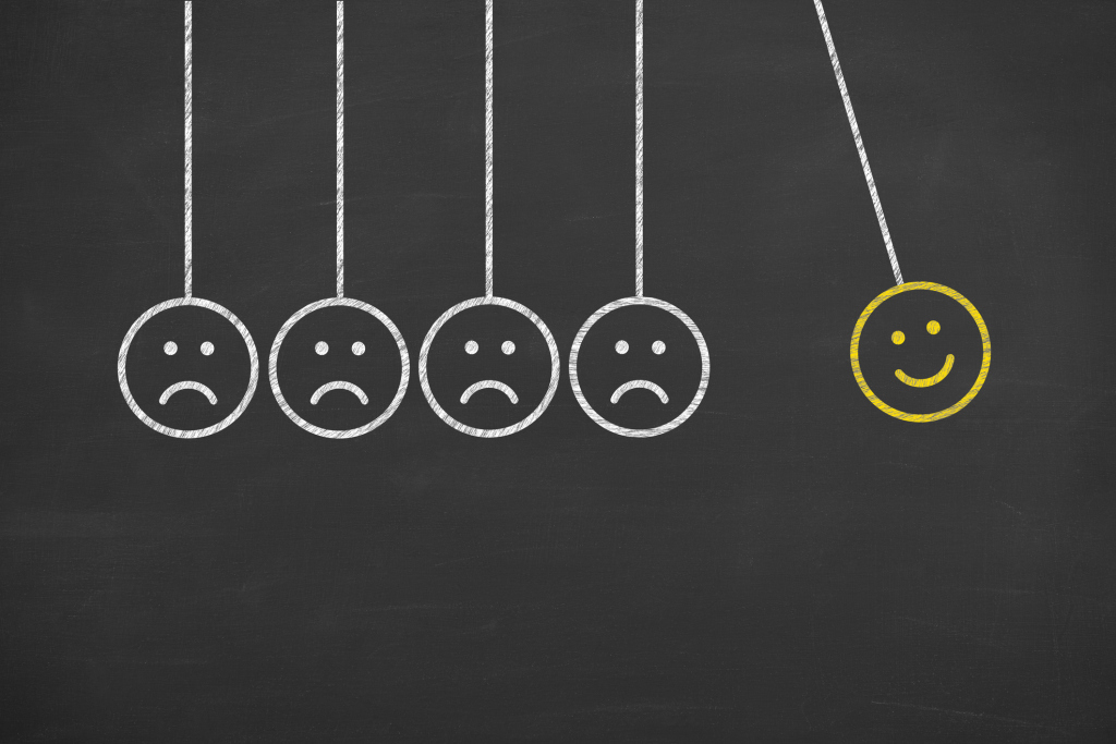 Lachendes Smiley nimmt Schwung, um vier schlecht gelaunte Smileys anzustupsen Lachendes Smiley nimmt Schwung, um vier schlecht gelaunte Smileys anzustupsen