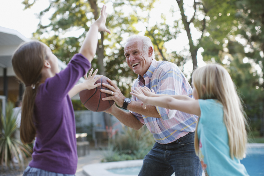 Senior spielt Ball mit Enkeln Senior spielt Ball mit Enkeln