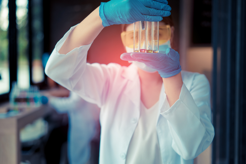Ärztin hält vier Reagenzgläser zwischen den Händen Ärztin hält vier Reagenzgläser zwischen den Händen