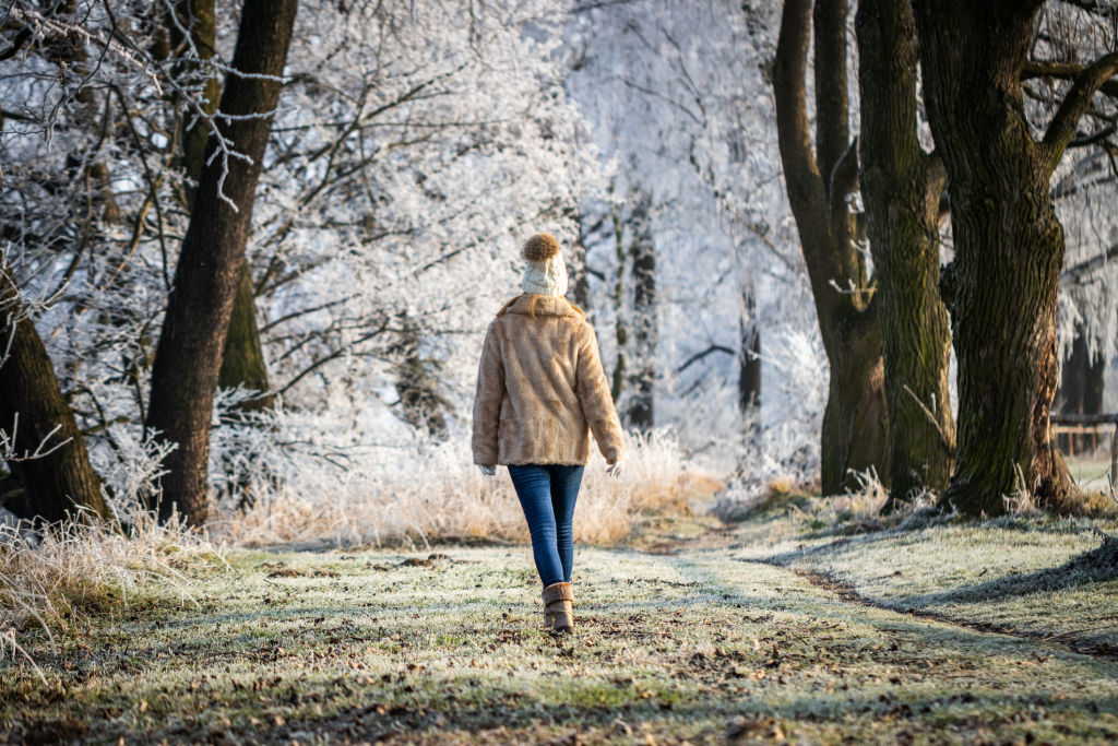 Frau geht in winterlichem Park spazieren Frau geht in winterlichem Park spazieren