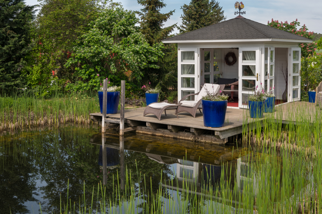 Schwimmteich mit Gartenhäuschen und kleinem Steg Schwimmteich mit Gartenhäuschen und kleinem Steg