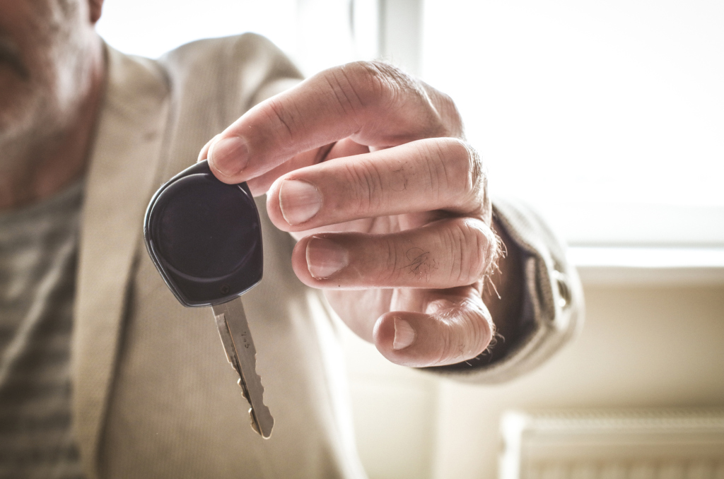Mann überreicht Autoschlüssel Mann überreicht Autoschlüssel