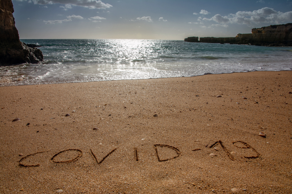 Strand mit Covid-19-Schrift Strand mit Covid-19-Schrift