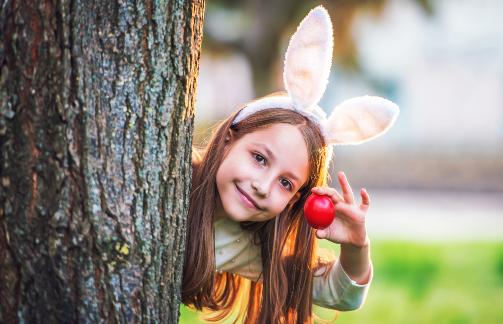Mädchen mit Hasenohren und rot gefärbtem Ei Mädchen mit Hasenohren und rot gefärbtem Ei