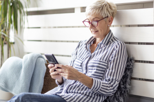 Seniorin schaut auf Smartphone-Screen Seniorin schaut auf Smartphone-Screen