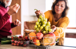 älteres Paar in der Küche, Gemüse und Obstschale älteres Paar in der Küche, Gemüse und Obstschale