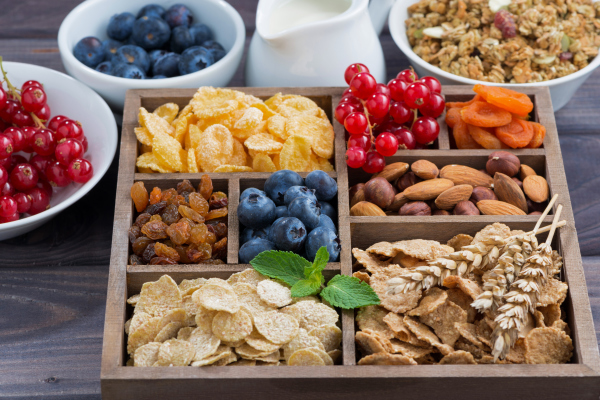 Frühstück mit Zerealien und anderen Zutaten in einer Holzkiste Frühstück mit Zerealien und anderen Zutaten in einer Holzkiste