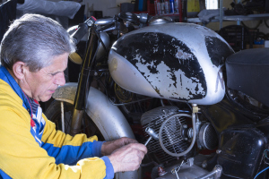 Mann schraubt an einem Motorrad Mann schraubt an einem Motorrad