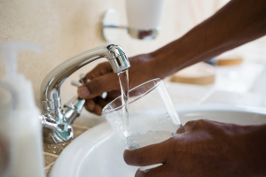 Wasser wird vom Wasserhahn abgefüllt Wasser wird vom Wasserhahn abgefüllt