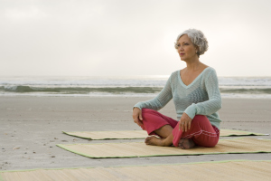 Frau sitzend auf einer Yogamatte Frau sitzend auf einer Yogamatte