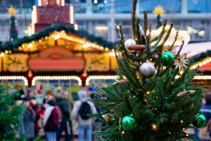 Weihnachtsmarkt mit Tannenzweigen im Vordergrund Weihnachtsmarkt mit Tannenzweigen im Vordergrund