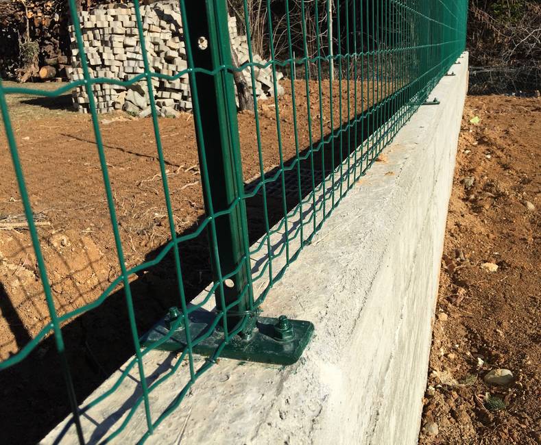 Green plastic coated sleeve anchored T-post For a wall installation