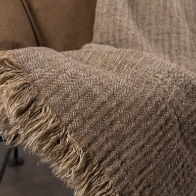 Rudo lininio pledo su eglutės raštu audinio vaizdas iš arti.