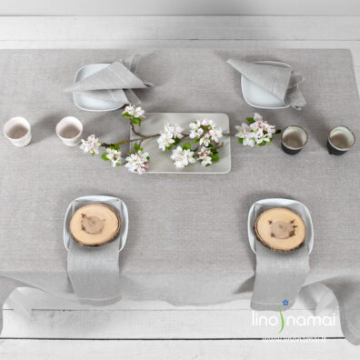 Raštuotoje lino staltiesėje suausti balti ir natūralios spalvos verpalai