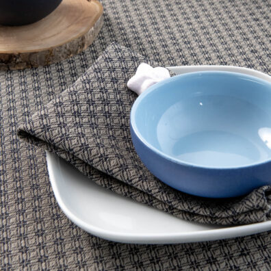 Pilkos ir tamsiai melynos spalvos lininė servetėle su raštu.