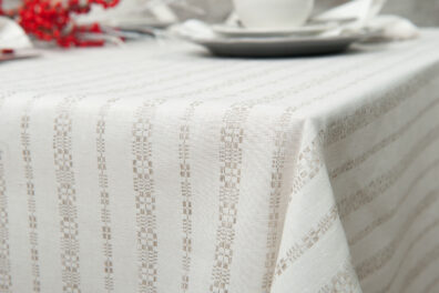 Lininė balta staltiesė su pilkais ornamentais.