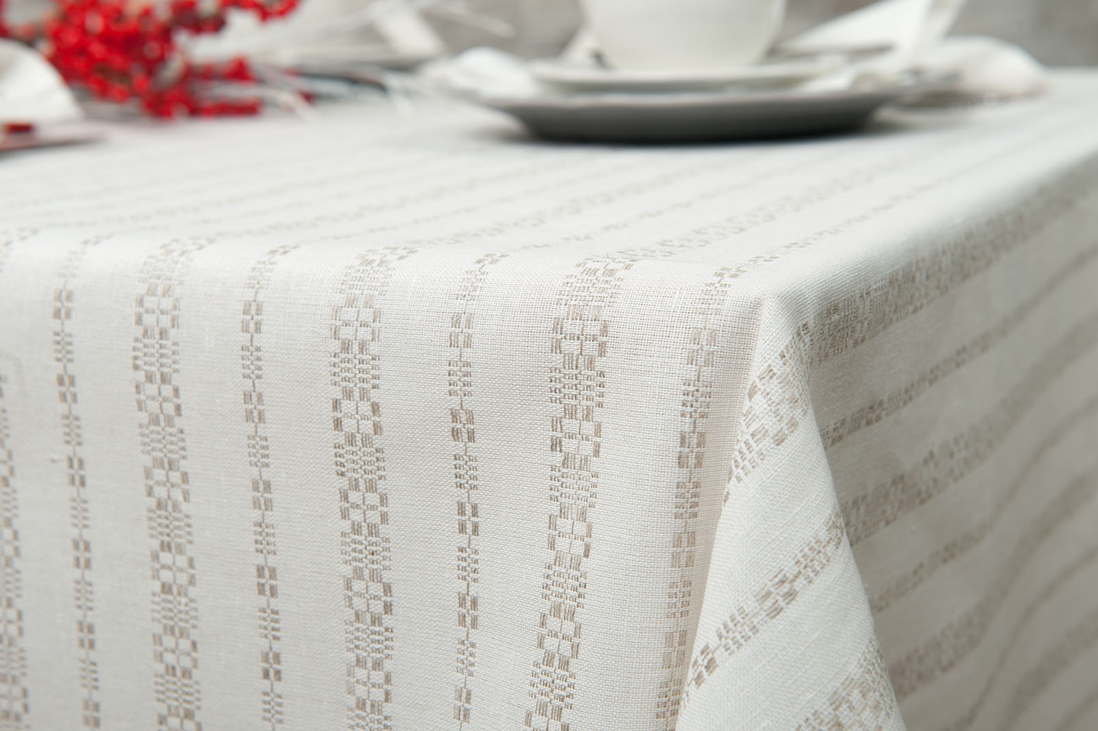 Lininė balta staltiesė su pilkais ornamentais.