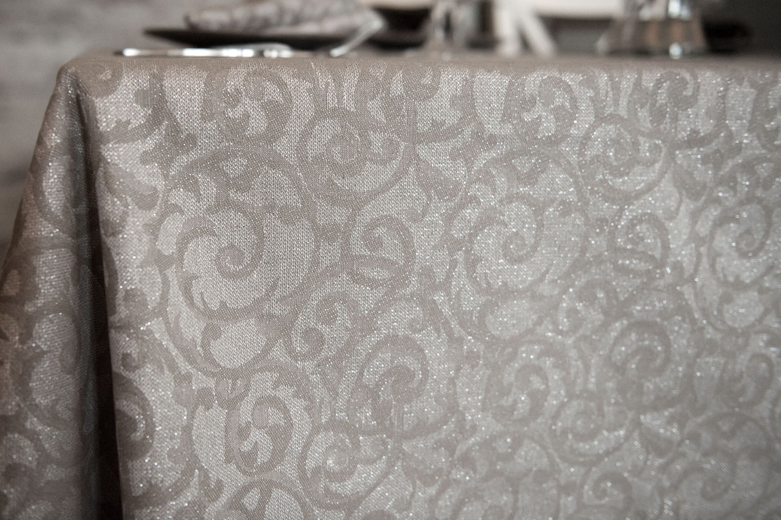 Pilka puslininė raštuota staltiesė su sidabro blizgučiu.