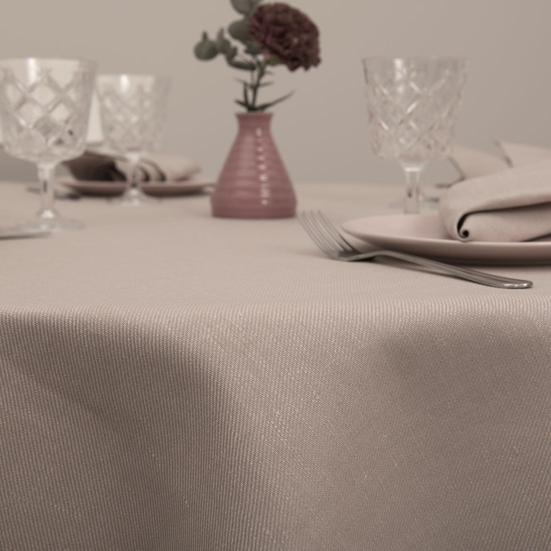 Apvali (ovali) staltiesė iš pastelinės rožinės spalvos audinio.