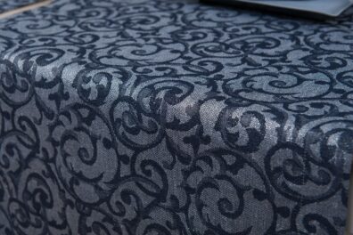 Lino – medvilnės stalo takelis su puošniais tamsiai mėlynais raštais melsvai pilkame sidabru blizgančiame fone