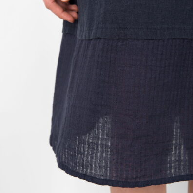Tamsiai mėlyna lininė suknelė su retesnio audinio apačia.