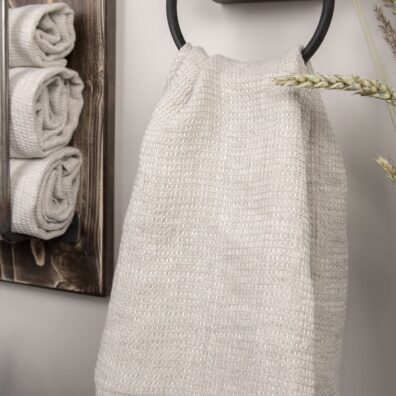 Šviesiai pilkos spalvos lininis rankšluostis voniai ar pirčiai.