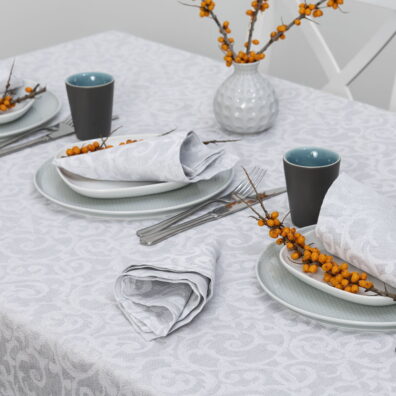 Puslininė šviesiai pilka raštuota staltiesė su sidabriniu blizgesiu.