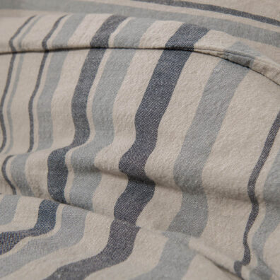 Lininė patalynė pilkai juodai dryžuota, jos audinys iš arti.