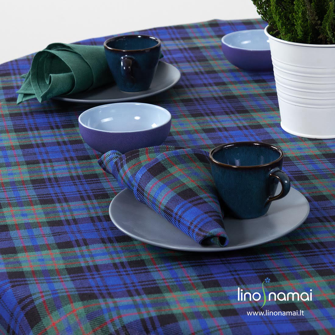 Apvali (ovali) puslininė staltiesė mėlynais, žaliais langeliais, juodomis, raudonomis juostelėmis