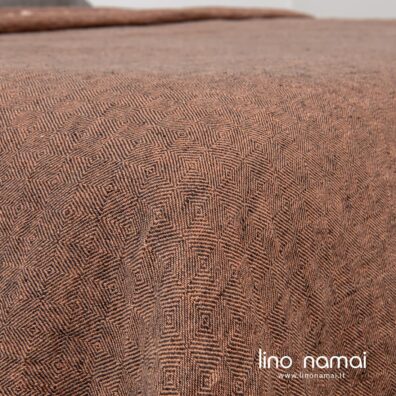 Lininės lovatiesės audinys austas iš tamsiai pilkų ir rusvų verpalų rombų raštu