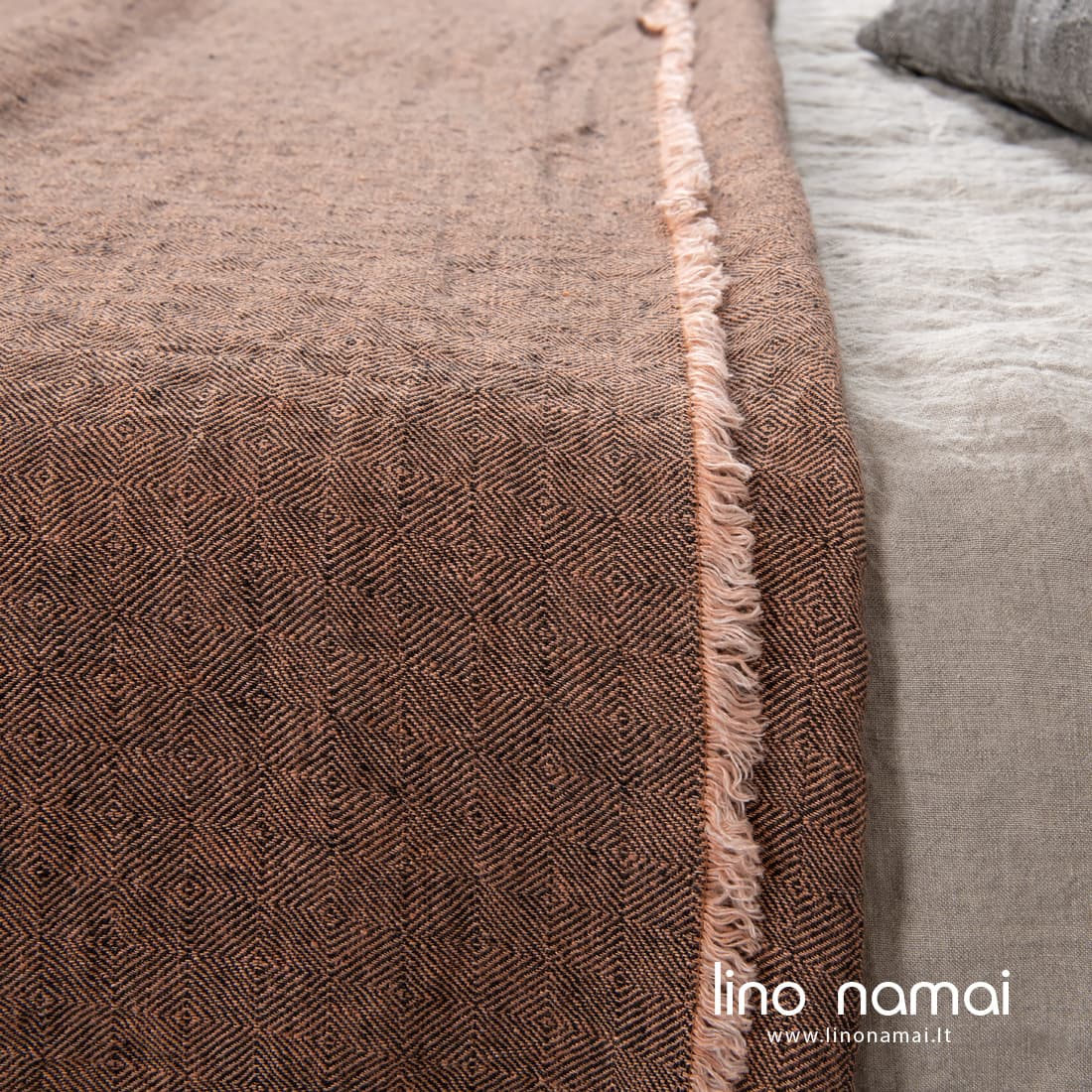 Pešiotais kutais puošta ruda raštuota lininė lovatiesė