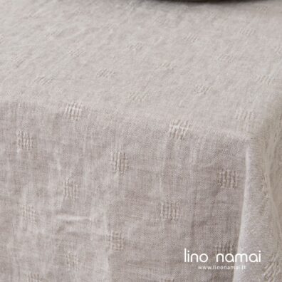 Šviesiai pilka skalbto lino staltiesė ažūriniais langeliais