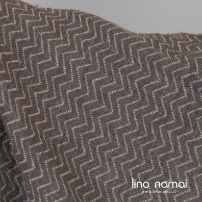 Pilka dvipusio lininio audinio pusė su rusvai pilkais zigzagais