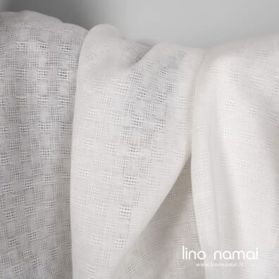 Lininis audinys baltas ažūriniais ir tankaus pynimo langeliais