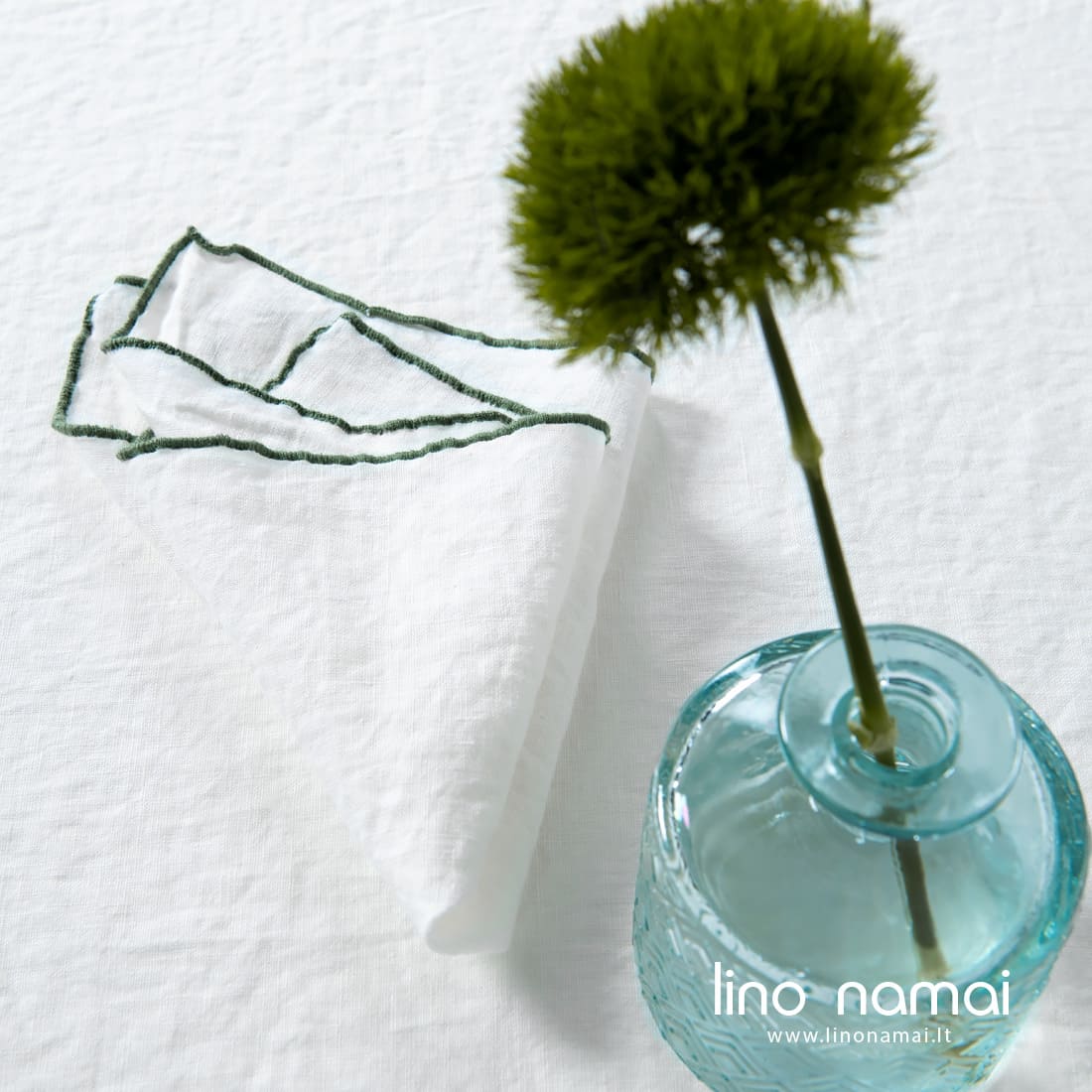 Pieno baltumo skalbto lino servetėlė su tankia dekoratyvine žalios spalvos siūle aplink