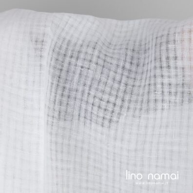 Ryškiai baltas lininis audinys permatomais langeliais