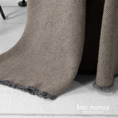 Puslininis pilkas pledas iš šviesiai ir tamsiai pilkų verpalų.