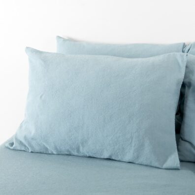 Lino - medvilnės pagalvės užvalkalas, kurio audinyje suausti melsvai žalsvi ir šviesiai mėlyni verpalai