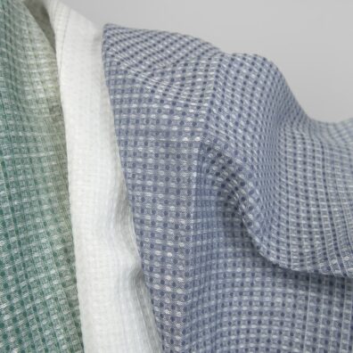 „Vaflinis“ medvilnės-kanapės audinys, kuriame suausti tamsiai žali, sendintos žalios, pieno baltumo (gelsvai balti), melsvai pilki ir mėlynai pilki verpalai