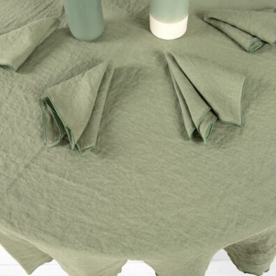 Lininė apvali žalsva staltiesė su tankia žalia dekoratyvine siūle aplink ir derančios servetėlės