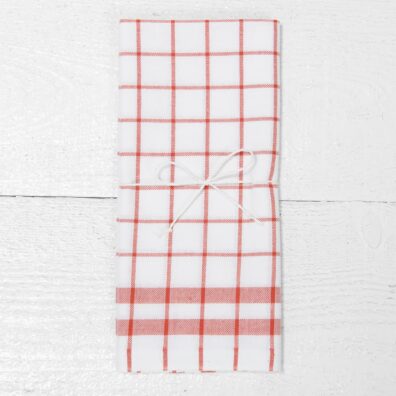 Medvilninis virtuvės rankšluostukas liepsnos raudonumo langeliais ryškiai baltame fone, perrištas dailia virvele